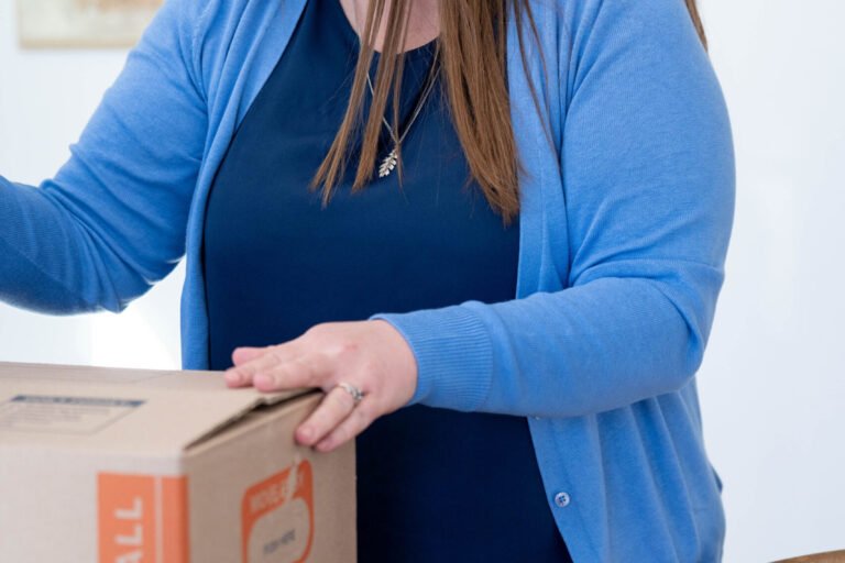 Smiling woman packing a moving box
