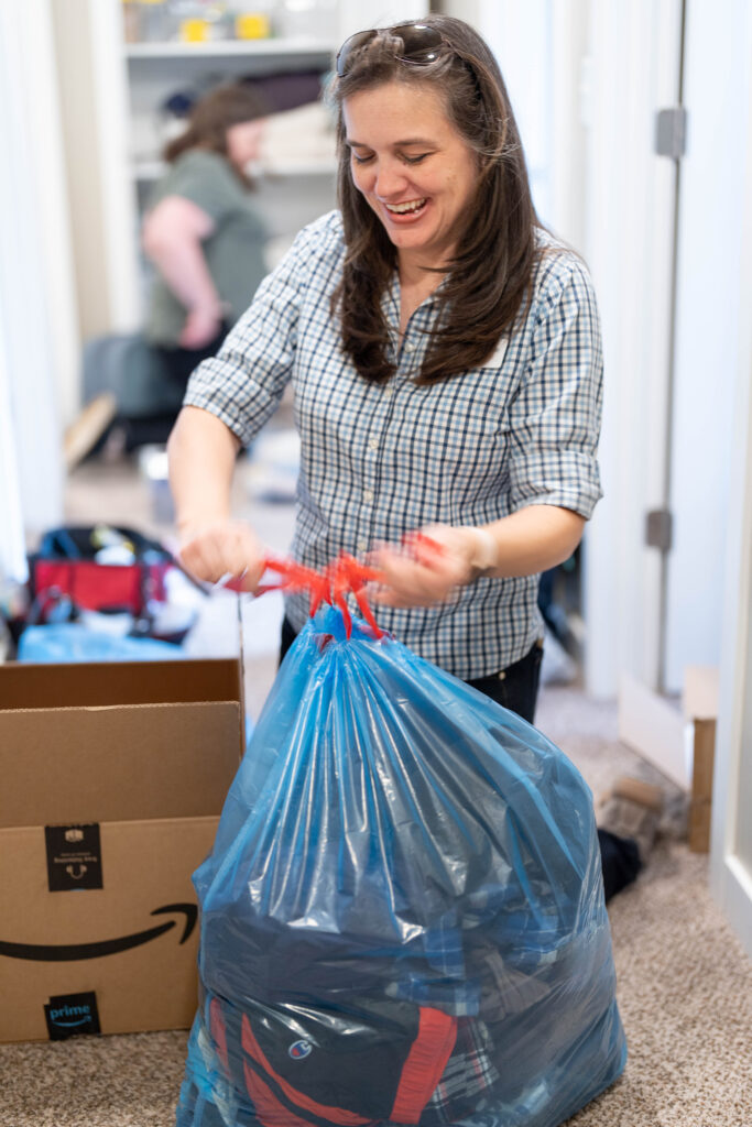 Professional organizer holding bag of client's donations